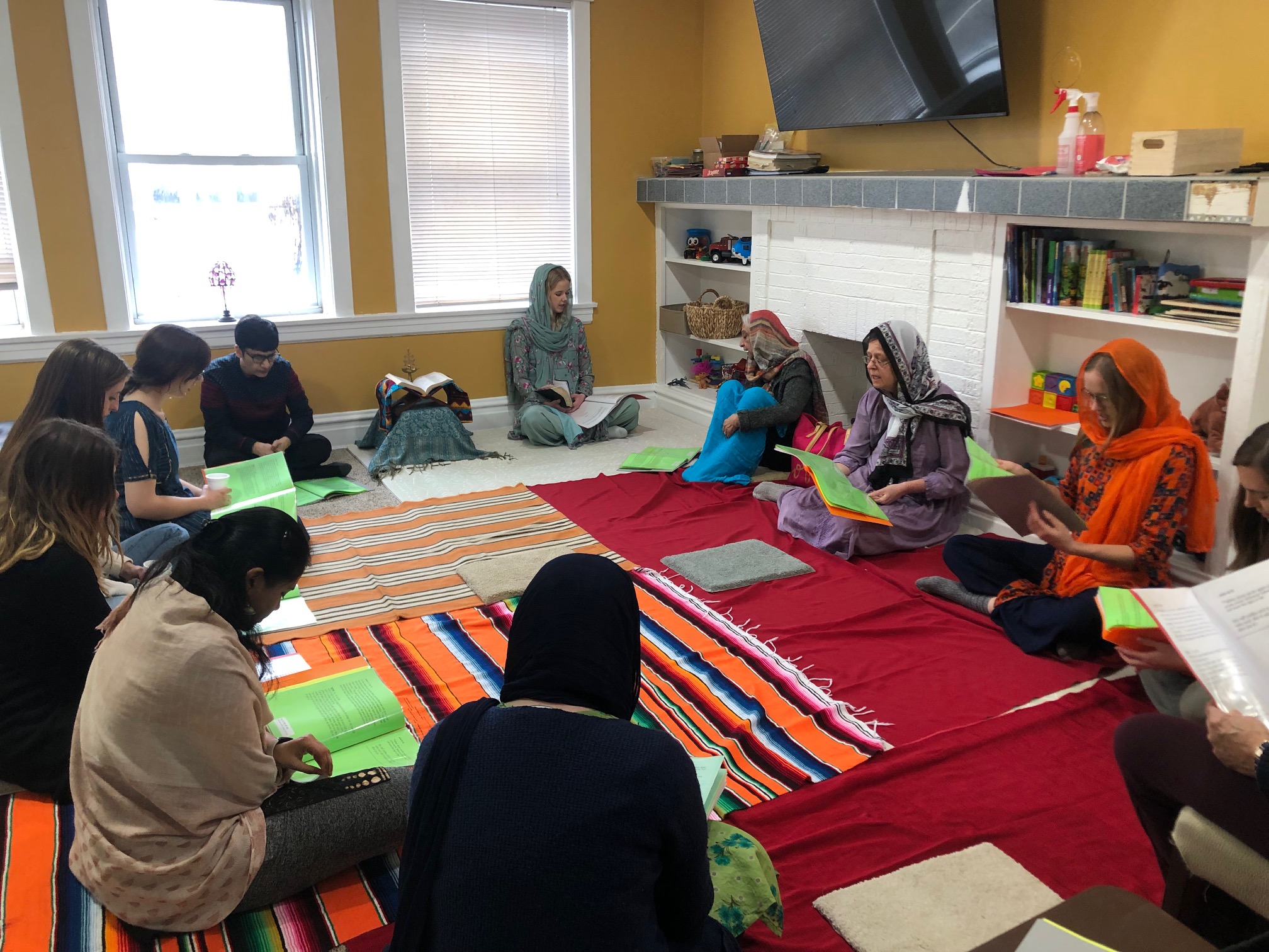 Women sit in a circle on the floor 