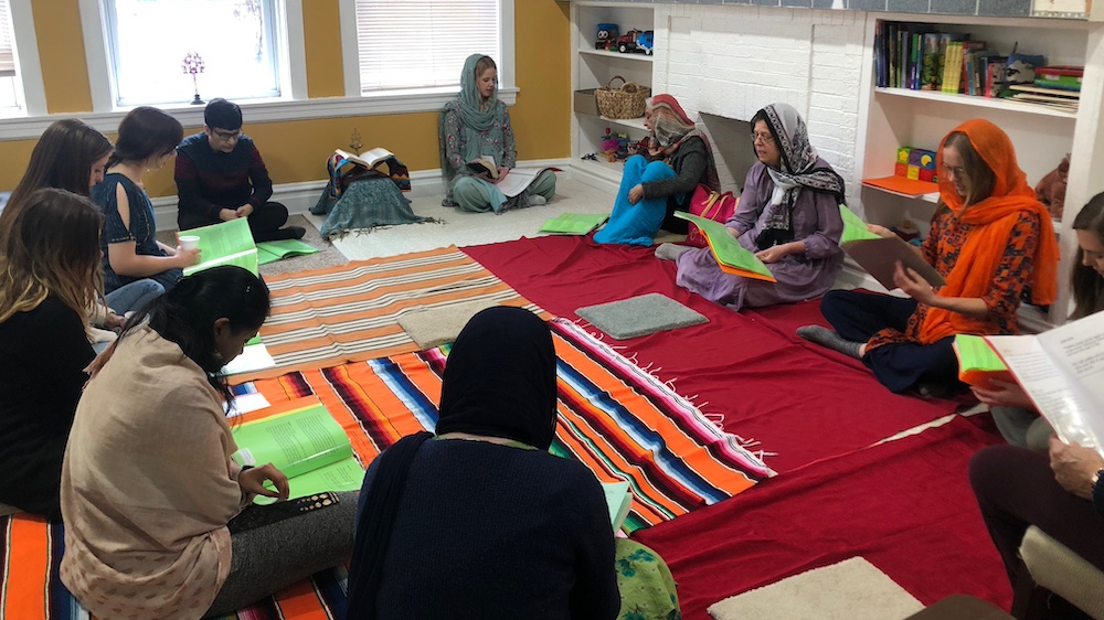 Women sit in a circle on the floor