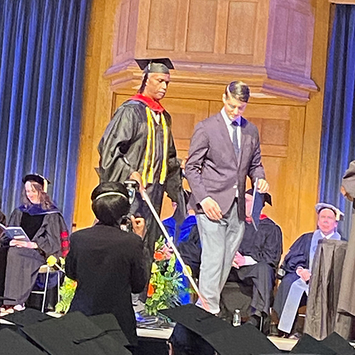 Cliff Kyle walking across the stage for his graduation ceremony