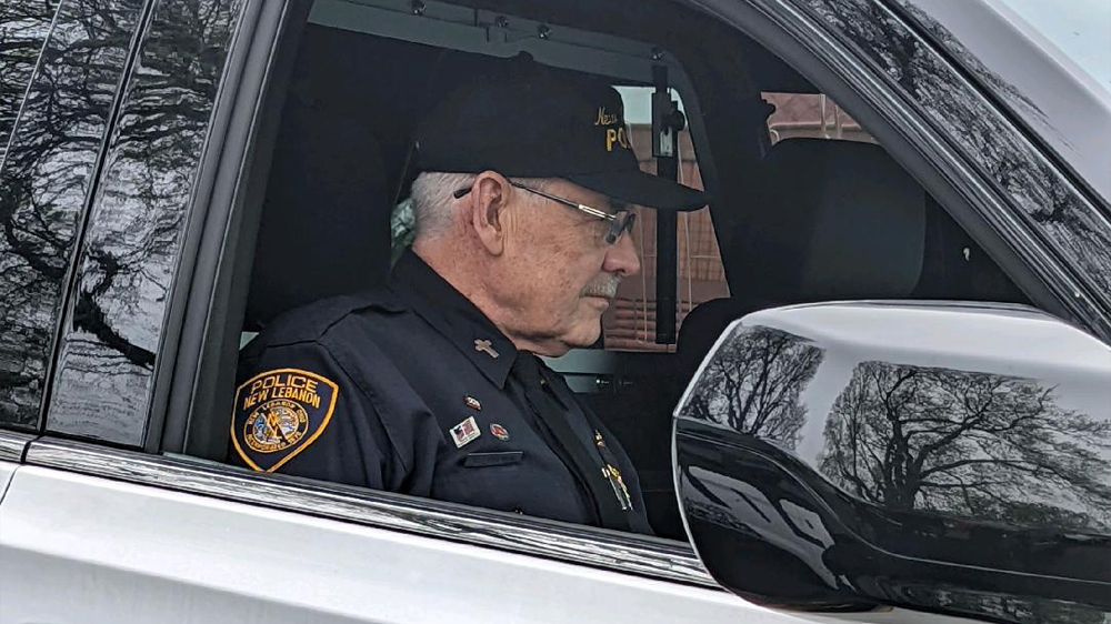 Laird Baldwin sits inside of a squad car